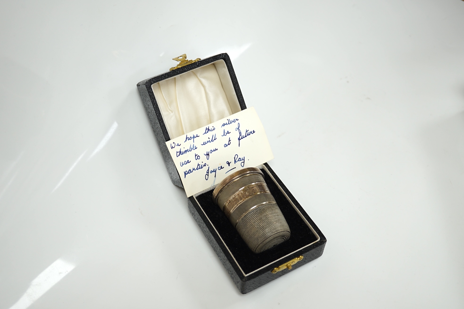 A cased modern silver 'Just a Thimbleful' thimble, 54mm, together with four assorted silver dressing table items and a whit metal bracelet. Condition - fair